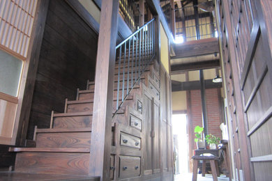 他の地域にある中くらいな和風のおしゃれな直階段 (木の蹴込み板、金属の手すり、板張り壁) の写真