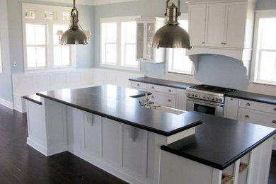 Inspiration for a dark wood floor kitchen remodel in Indianapolis with shaker cabinets, white cabinets, solid surface countertops, stainless steel appliances and an island