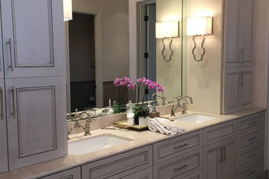 Large transitional master bathroom in Phoenix with recessed-panel cabinets, grey cabinets, a one-piece toilet, white walls, an undermount sink, a freestanding tub, a corner shower, limestone floors, marble benchtops and beige floor.