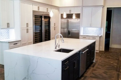 Inspiration for a large transitional u-shaped dark wood floor and brown floor eat-in kitchen remodel in Miami with shaker cabinets, white cabinets, an island, stainless steel appliances, a farmhouse sink, white countertops, marble countertops and gray backsplash