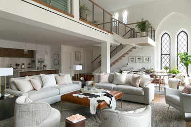 Diseño de salón tipo loft y abovedado contemporáneo con paredes blancas, suelo de madera clara y suelo marrón