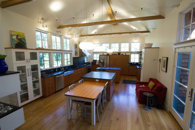 Eat-in kitchen - large rustic u-shaped medium tone wood floor eat-in kitchen idea in Other with a farmhouse sink, flat-panel cabinets, medium tone wood cabinets, soapstone countertops, stainless steel appliances and two islands