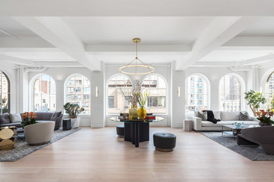 This is an example of a large contemporary formal open concept living room in New York with white walls, light hardwood floors, no fireplace, no tv and beige floor.