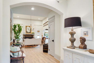 Large traditional hallway in Atlanta with white walls, light hardwood floors and brown floor.