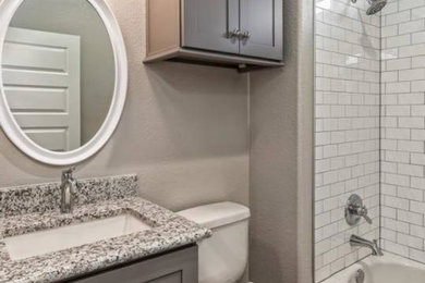 Example of a trendy white tile and subway tile porcelain tile and gray floor bathroom design in Los Angeles with shaker cabinets, gray cabinets, a two-piece toilet, an undermount sink, granite countertops and gray countertops