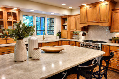 Example of a transitional medium tone wood floor kitchen design in Indianapolis with an undermount sink, medium tone wood cabinets, quartzite countertops, white backsplash, ceramic backsplash, an island and beige countertops