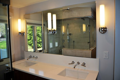 Double shower - small modern master gray tile and ceramic tile ceramic tile and gray floor double shower idea in Boston with flat-panel cabinets, dark wood cabinets, a one-piece toilet, gray walls, an undermount sink, quartz countertops and a hinged shower door