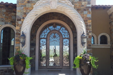 This is an example of a mid-sized mediterranean tile porch design in Phoenix with a roof extension.