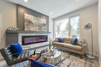 Living room - small contemporary open concept laminate floor and gray floor living room idea in Edmonton with white walls and a ribbon fireplace