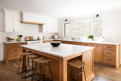 Eat-in kitchen - mid-sized transitional l-shaped medium tone wood floor eat-in kitchen idea in New York with a drop-in sink, beaded inset cabinets, white cabinets, solid surface countertops, white backsplash, porcelain backsplash, an island and white countertops