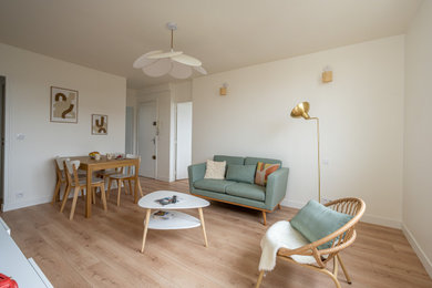 Diseño de sala de estar de tamaño medio sin chimenea con paredes blancas, suelo laminado y televisor independiente