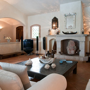 Großes, Offenes Mediterranes Wohnzimmer mit weißer Wandfarbe, Terrakottaboden, Kamin, Kaminsims aus Stein, Eck-TV und rosa Boden in Sonstige