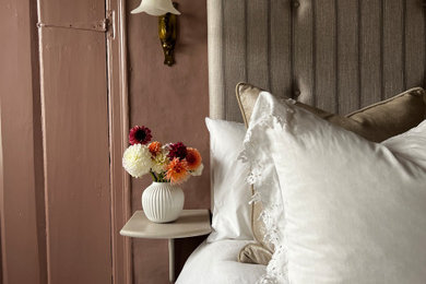 Modelo de dormitorio principal grande con paredes rosas, moqueta y suelo beige