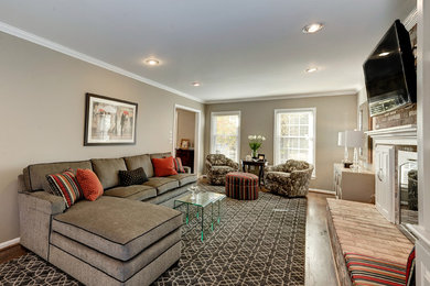 Living room - mid-sized traditional enclosed medium tone wood floor living room idea in DC Metro with beige walls, a standard fireplace, a brick fireplace and a wall-mounted tv