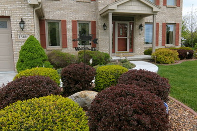 Example of a mid-sized classic beige two-story brick exterior home design in Other with a shingle roof