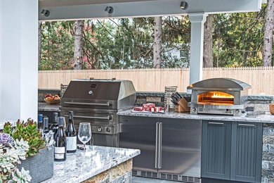 Inspiration for a large transitional backyard stone patio kitchen remodel in Boise with a pergola