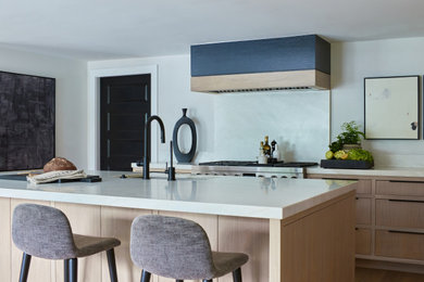 Eat-in kitchen - large modern l-shaped light wood floor and beige floor eat-in kitchen idea in New York with an undermount sink, flat-panel cabinets, beige cabinets, quartzite countertops, gray backsplash, marble backsplash, stainless steel appliances, an island and white countertops