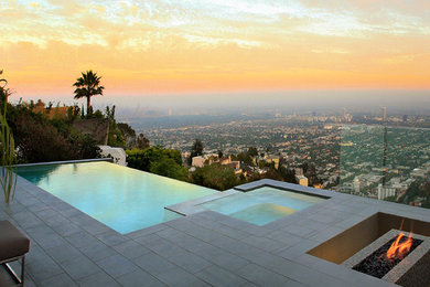 Large minimalist backyard tile and rectangular infinity hot tub photo in Los Angeles