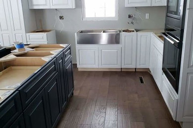 Modelo de cocina de estilo de casa de campo con armarios estilo shaker, encimera de cuarcita, una isla y encimeras blancas