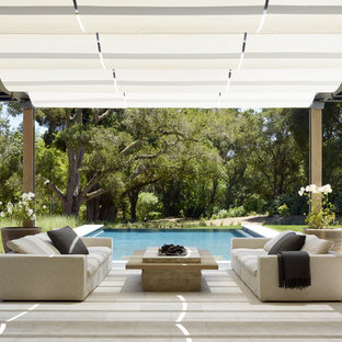 На фото: пергола во дворе частного дома на заднем дворе в стиле кантри с костровой чашей с