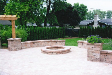 Diseño de patio clásico de tamaño medio sin cubierta en patio trasero con adoquines de ladrillo y brasero
