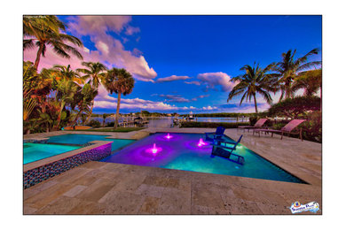 Huge minimalist courtyard stone and custom-shaped lap pool house photo in Tampa