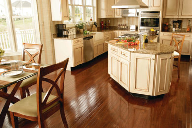 Inspiration for a large contemporary l-shaped dark wood floor and brown floor eat-in kitchen remodel in Orange County with a farmhouse sink, beaded inset cabinets, beige cabinets, granite countertops, beige backsplash, stainless steel appliances and an island