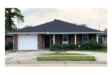 Multicolored exterior home idea in New Orleans with a hip roof, a shingle roof and a black roof