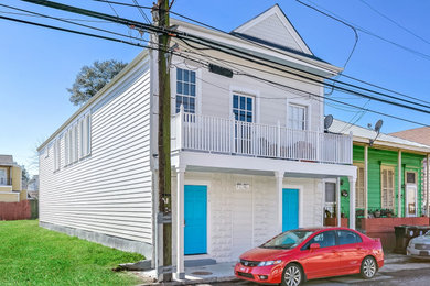Example of a large classic beige two-story wood exterior home design in New Orleans with a mixed material roof