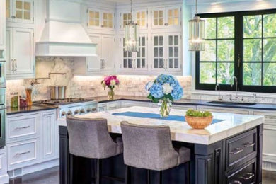 Example of a mid-sized classic l-shaped dark wood floor and brown floor enclosed kitchen design in Orange County with an undermount sink, beaded inset cabinets, white cabinets, granite countertops, beige backsplash, stainless steel appliances, an island and black countertops