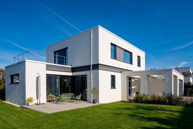 Mittelgroßes, Zweistöckiges Modernes Einfamilienhaus mit Putzfassade, weißer Fassadenfarbe und Flachdach in Sonstige