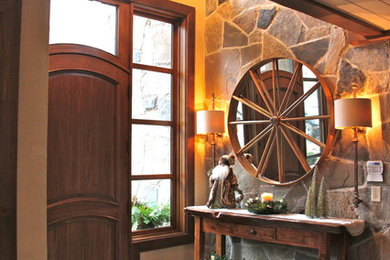 Example of a mountain style porcelain tile entryway design in Toronto with beige walls and a dark wood front door