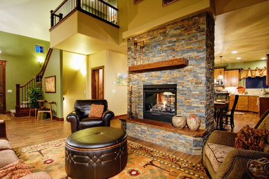 This is an example of a small arts and crafts open concept living room in Denver with beige walls, medium hardwood floors, a two-sided fireplace and a stone fireplace surround.