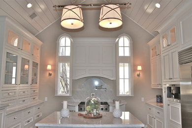 Kitchen pantry - large traditional galley ceramic tile kitchen pantry idea in Houston with a drop-in sink, raised-panel cabinets, white cabinets, marble countertops, gray backsplash, stainless steel appliances and an island
