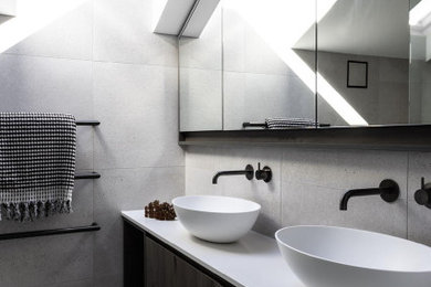 Modern bathroom in Perth with recessed-panel cabinets, black cabinets, an open shower, porcelain tile, grey walls, porcelain floors, a vessel sink, engineered quartz benchtops, grey floor, an open shower, white benchtops, a double vanity and a freestanding vanity.
