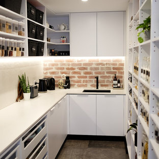 Réalisation d'une arrière-cuisine minimaliste en U de taille moyenne avec un évier encastré, un placard sans porte, des portes de placard blanches, un plan de travail en quartz modifié, une crédence multicolore, une crédence en brique, un sol en carrelage de porcelaine, un sol gris et un plan de travail blanc.