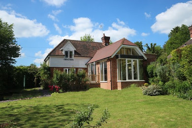 Imagen de fachada de casa marrón clásica de tamaño medio de una planta con revestimiento de ladrillo, tejado a la holandesa y tejado de teja de barro