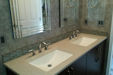 Example of a mid-sized trendy master brown tile porcelain tile doorless shower design in Omaha with flat-panel cabinets, dark wood cabinets, a two-piece toilet, gray walls, an integrated sink and onyx countertops