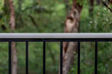 Example of a large minimalist backyard second story privacy and mixed material railing deck design in Dallas