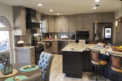 Mid-sized elegant porcelain tile eat-in kitchen photo in Oklahoma City with a farmhouse sink, shaker cabinets, granite countertops, glass tile backsplash and an island