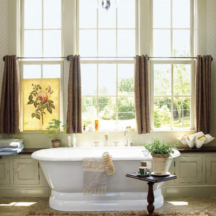 Réalisation d'une salle de bain champêtre avec une baignoire indépendante, un mur beige et un sol en ardoise.