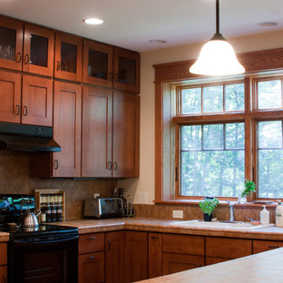 Idéer för att renovera ett stort funkis kök, med skåp i mellenmörkt trä, kaklad bänkskiva, svarta vitvaror och en halv köksö