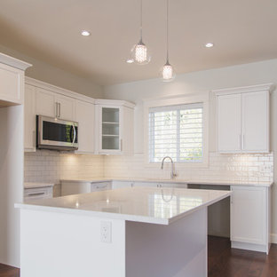 This is an example of a kitchen pantry in Other with a double-bowl sink, white cabinets, quartz benchtops, white splashback, ceramic splashback, stainless steel appliances, dark hardwood floors, with island, brown floor, yellow benchtop and shaker cabinets.