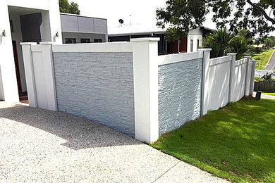 Photo of a mid-sized mediterranean two-storey concrete grey house exterior in Gold Coast - Tweed with a flat roof and a shingle roof.