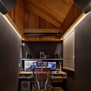 Design ideas for a small modern home office and library in Tokyo with multi-coloured walls, medium hardwood flooring, a built-in desk and brown floors.