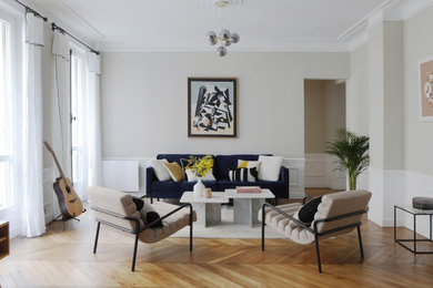 Inspiration pour un grand salon design avec un mur beige et parquet clair.