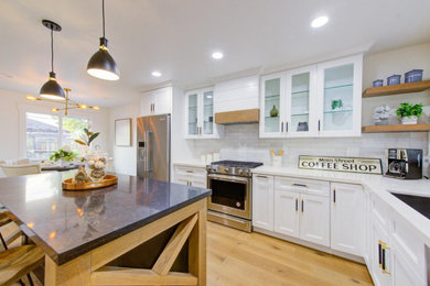 Inspiration for a mid-sized craftsman l-shaped light wood floor and brown floor eat-in kitchen remodel in San Francisco with an undermount sink, shaker cabinets, white cabinets, quartzite countertops, white backsplash, subway tile backsplash, stainless steel appliances, an island and white countertops