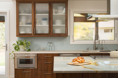 Large minimalist l-shaped light wood floor open concept kitchen photo in Denver with an undermount sink, flat-panel cabinets, dark wood cabinets, blue backsplash, glass tile backsplash, stainless steel appliances, an island and blue countertops