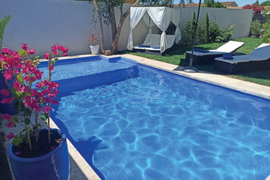 Diseño de piscina minimalista a medida en patio con suelo de hormigón estampado