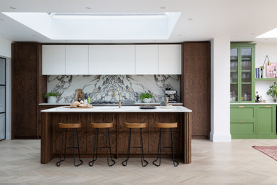 Inspiration for a medium sized scandinavian single-wall kitchen/diner in London with a submerged sink, dark wood cabinets, engineered stone countertops, porcelain splashback, stainless steel appliances, light hardwood flooring, an island and a feature wall.